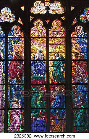 Stock Image - Czech Republic, Colorful stained glass windows with depiction of religious figures; Prague. Fotosearch