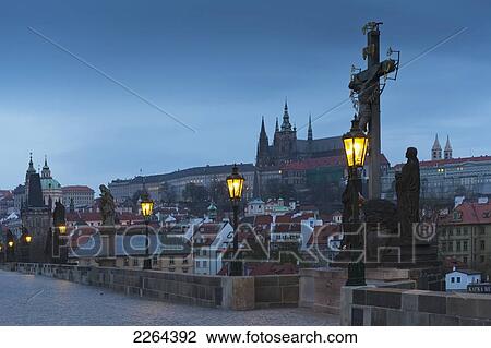 Stock Image - Czech Republic, Sculpture depicting Crucifixion of Christ with cityscape in background; Prague. Fotosearch