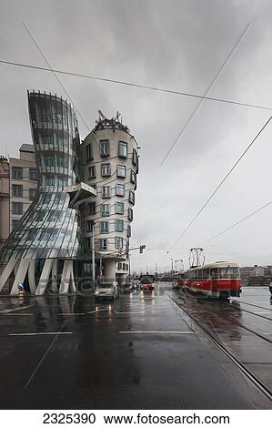 Czech Republic, Streetcar on wet road passes by building with curved architecture; Prague View Large Photo Image Stock Image - Czech Republic, Streetcar on wet road passes by building with curved architecture; Prague. Fotosearch