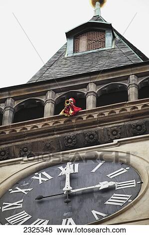 Czech Republic, Trumpeter on balcony of building with large clock; Prague View Large Photo Image Stock Photo - Czech Republic, Trumpeter on balcony of building with large clock; Prague. Fotosearch