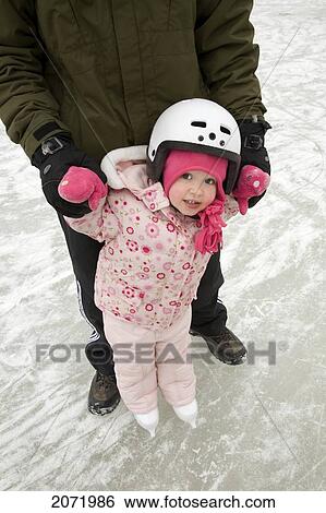 Stock Photograph - Dad Teaching Daughter To Skate, Ontario. Fotosearch