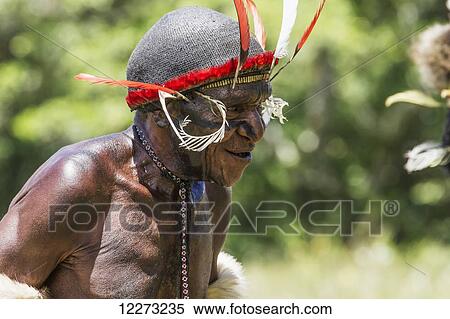 Stock Photography - Dani man wearing an elaborate headdress of bird of paradise or cassowary feathers, Obia Village, Baliem Valley, Central Highlands of Western New Guinea, Papua, Indonesia. Fotosearch
