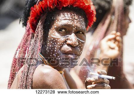 Stock Photo - Dani woman smoking a cigarette, Obia Village, Baliem Valley, Central Highlands of Western New Guinea, Papua, Indonesia. Fotosearch