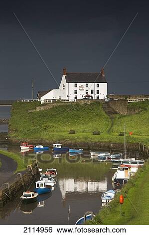Stock Photograph - Dark Storm Clouds Over A Village On The Coast; Seaton Sluice Northumberland England. Fotosearch