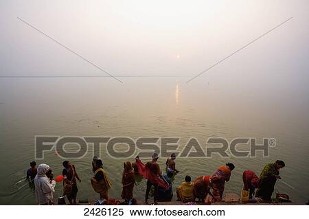 Stock Photography - Dawn bathers at the ghats on the ganges; Varanasi, India. Fotosearch