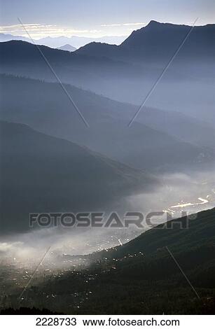 Stock Image - Dawn Mist Rising Above Thimpu, The Capital Of Bhutan Photo: Jill Mead/Axiom Nov 2003. Fotosearch
