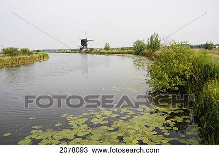 De Blokker Windmill, Built Around 1740 Along Nieuwe Waterschap To Drain The Excess Water From The Alblasserwaard Polders, Kinderdijk, Netherlands View Large Photo Image Stock Image - De Blokker Windmill, Built Around 1740 Along Nieuwe Waterschap To Drain The Excess Water From The Alblasserwaard Polders, Kinderdijk, Netherlands. Fotosearch