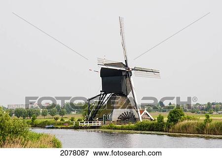 De Blokker Windmill, Built Around 1740 Along Nieuwe Waterschap To Drain The Excess Water From The Alblasserwaard Polders, Kinderdijk, Netherlands View Large Photo Image Stock Photo - De Blokker Windmill, Built Around 1740 Along Nieuwe Waterschap To Drain The Excess Water From The Alblasserwaard Polders, Kinderdijk, Netherlands. Fotosearch