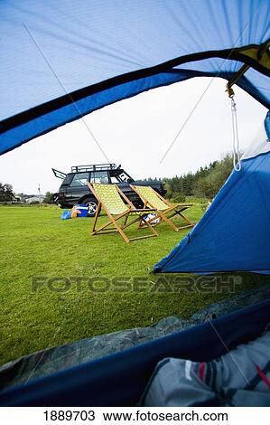 Stock Image - Deck Chairs And Car Through The Open Door Of The Tent. Fotosearch
