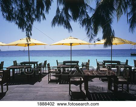 Stock Image - Deck Chairs, Tables And Umbrellas On Beach. Fotosearch