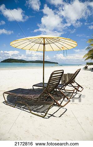 Deck Chairs Under Parasol On White Sandy Beach With Palm Trees Overlooking Blue Sea. Pantai Cenang (Cenang Beach), Pulau Langkawi, Malaysia, South East Asia. View Large Photo Image Stock Photograph - Deck Chairs Under Parasol On White Sandy Beach With Palm Trees Overlooking Blue Sea. Pantai Cenang (Cenang Beach), Pulau Langkawi, Malaysia, South East Asia.. Fotosearch