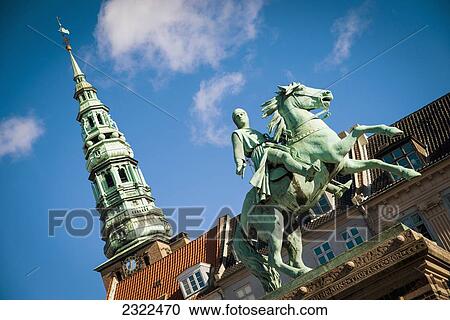 Stock Image - Denmark, Bishop Absalon equestrian statue in Hojbro Plads and views of Nikolaj on the background; Copenhagen. Fotosearch