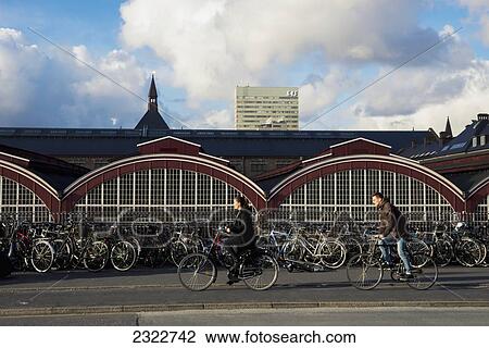 Stock Image - Denmark, Cyclists passing in front of Central Station; Copenhagen. Fotosearch