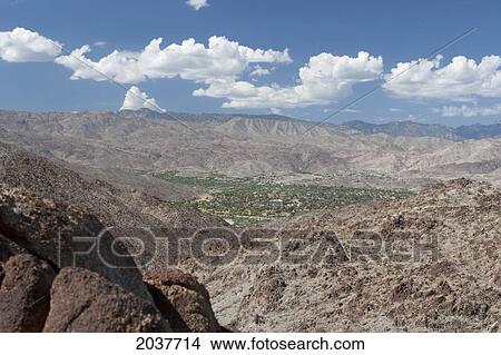 Picture - Desert Mountain Landscape And Green Valley Below With Blue Sky And Clouds; Palm Springs California United States Of America. Fotosearch