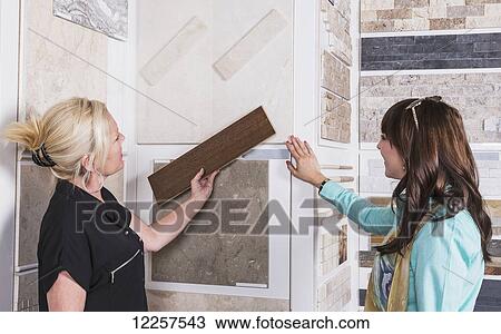 Stock Image - Design consultant and interior designer selecting tiles in showroom of tile store; Edmonton, Alberta, Canada. Fotosearch