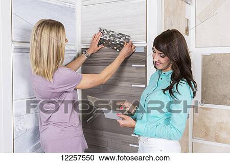 Stock Image - Design consultant and interior designer selecting tiles in showroom of tile store; Edmonton, Alberta, Canada. Fotosearch