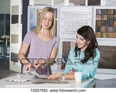 Stock Image - Design consultant and interior designer selecting tiles in showroom of tile store; Edmonton, Alberta, Canada. Fotosearch