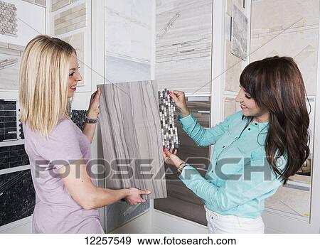 Stock Photo - Design consultant and interior designer selecting tiles in showroom of tile store; Edmonton, Alberta, Canada. Fotosearch