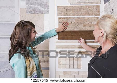 Stock Photography - Design consultant and interior designer selecting tiles in showroom of tile store; Edmonton, Alberta, Canada. Fotosearch