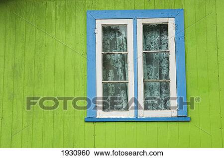 Stock Image - Detail Of A Green Wooden House With Blue Window Trim At Windward; Grenada, Caribbean. Fotosearch