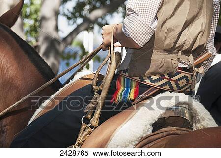Stock Photography - Detail of Argentine gaucho on his horse; Argentina. Fotosearch