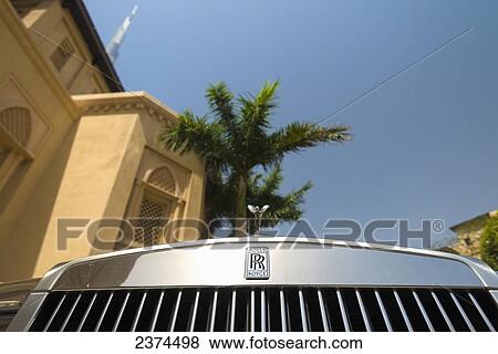 Detail of chrome plated Rolls Royce beneath palm tree and traditional arabic style hotel with the Burj Khalifa behind; Dubai, United Arab Emirates View Large Photo Image Stock Photo - Detail of chrome plated Rolls Royce beneath palm tree and traditional arabic style hotel with the Burj Khalifa behind; Dubai, United Arab Emirates. Fotosearch