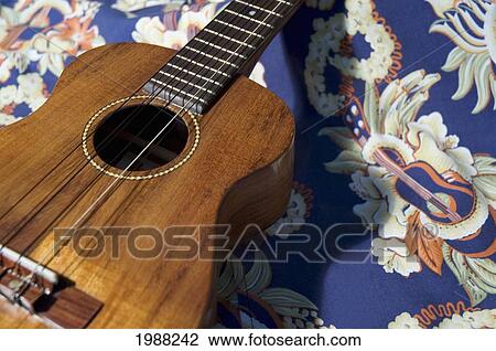 Stock Image - Detail Of Handmade Koa Ukulele On Aloha Print Background. Fotosearch