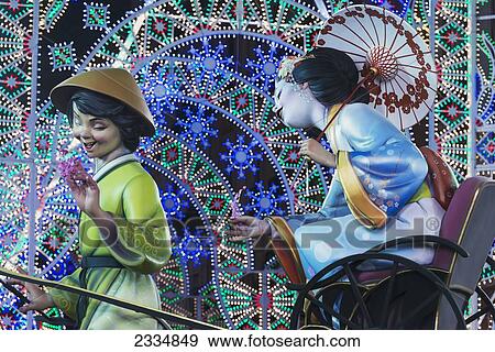 Stock Photo - Detail Of Large Falla Of Japanese Lady Being Pulled On Rickshaw By Man Displayed On Street As Part Of Fallas Festival; Valencia, Spain. Fotosearch