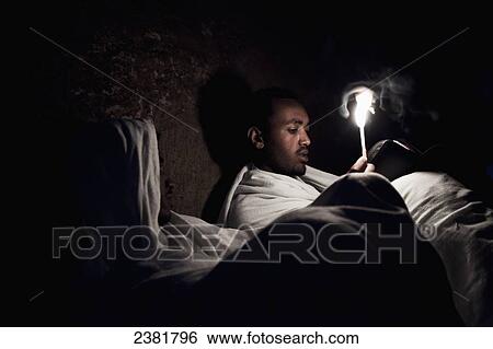 Stock Photograph - Details of nighttime worship celebrations taking place in the rock-hewn churches during Orthodox Easter; Lalibela, Ethiopia. Fotosearch