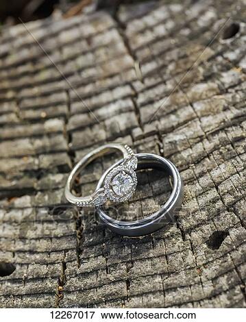 Stock Photo - Diamond engagement ring and wedding band on wood grain; Cle Elum, Washington, United States of America. Fotosearch