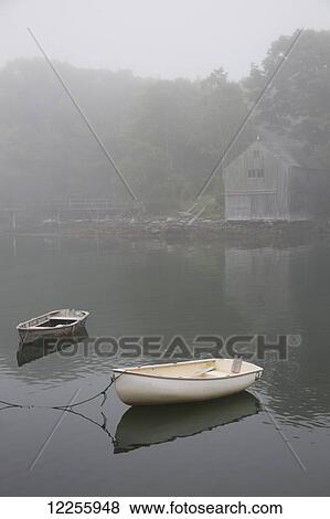 Stock Photo - Dinghys and boathouse in fog; New Harbor, Maine, United States of America. Fotosearch