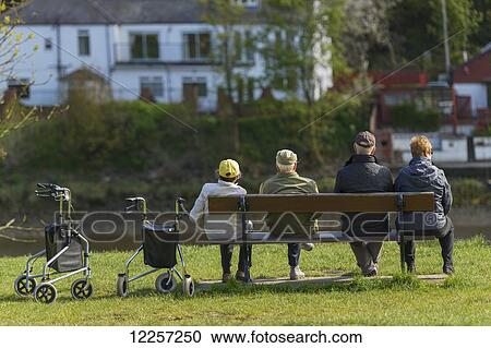 Stock Image - Disabled people and their caregivers relaxing by the River Tyne; Newburn, Newcastle upon Tyne, England. Fotosearch