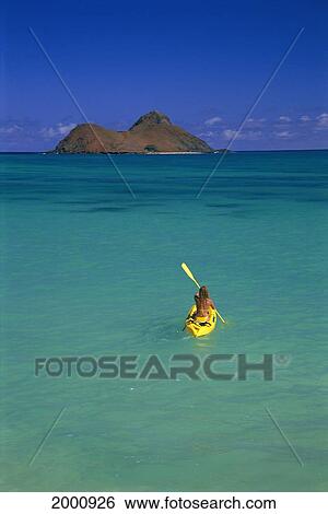 Stock Photograph - Distant View From Behind Woman Kayak Out To Island, Calm Turquoise Ocean Blue Sky. Fotosearch