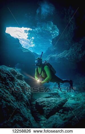 Stock Photograph - Diving into one of the underwater caves that surround Niue; Niue Island. Fotosearch