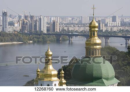 Stock Image - Domes of the Lower Lavra of the Caves Monastery with the River Dnipro and Eastern suburbs beyond; Kiev, Ukraine. Fotosearch
