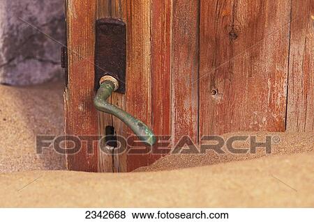 Stock Photo - Doorknob And Sand; Kolmanskop Ghost Town; Namibia. Fotosearch