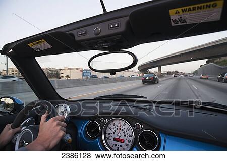 Stock Photo - Driving in a convertible with the top down; California, United States of America. Fotosearch