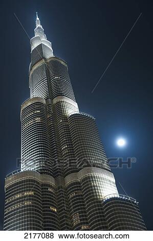 Stock Photo - Dubai, Uaemoon And Moving Clouds Behind The Burj Khalifa At Night. Fotosearch