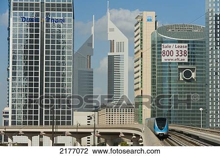Stock Image - Dubai, Uaetrain In Front Of Office Blocks. Fotosearch