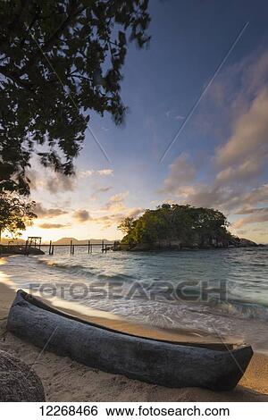 Stock Photograph - Dugout canoe on small beach on Mumbo Island, Lake Malawi; Malawi. Fotosearch