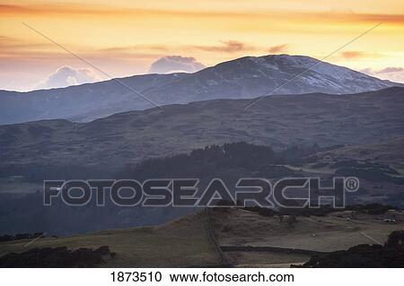 Stock Image - Dumfries, Scotland; A Hilly Landscape At Sunset. Fotosearch