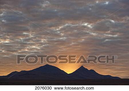 Stock Image - Early Morning Sunlight Shining From Behind A Mountain Along The Dempster Highway; Yukon Canada. Fotosearch