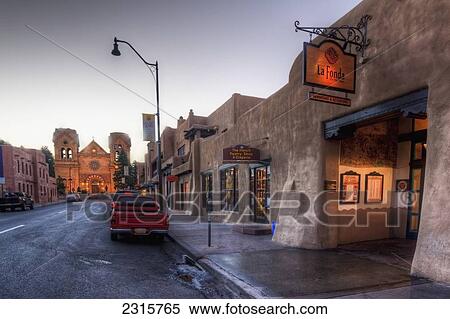Stock Photography - East San Francisco Street looking toward St. Francis of Assisi Cathedral and La Fonda Hotel at dawn; Santa Fe, New Mexico, USA. Fotosearch