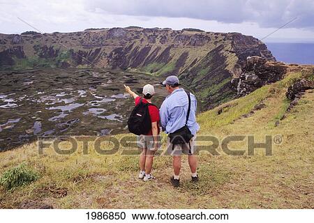 Easter Island, Rano Kau Crater, Couple Hiking At Edge Of Cliff, Ocean In Background. View Large Photo Image Stock Image - Easter Island, Rano Kau Crater, Couple Hiking At Edge Of Cliff, Ocean In Background.. Fotosearch
