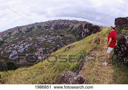 Stock Image - Easter Island, Rano Kau Crater, Hiker On Trail At Edge Of Cliff.. Fotosearch