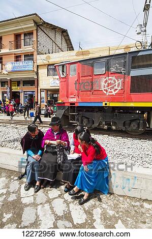 Stock Photograph - Ecuadorian women sitting by the railway station, Guamote, Chimborazo, Ecuador. Fotosearch