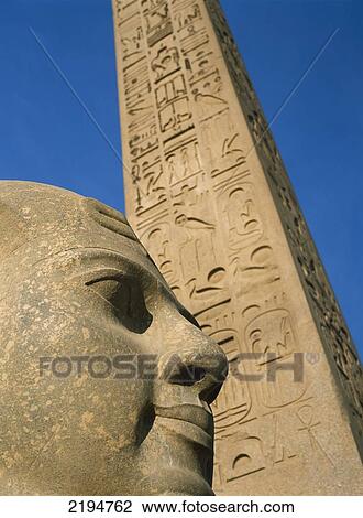 Stock Image - Egypt, Detail of head of pharaoh in front of obelisk at entrance to Luxor Temple; Luxor. Fotosearch