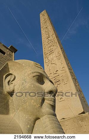 Stock Photo - Egypt, Large pharaoh's head statue and obelisk beside entrance to Luxor Temple; Luxor. Fotosearch