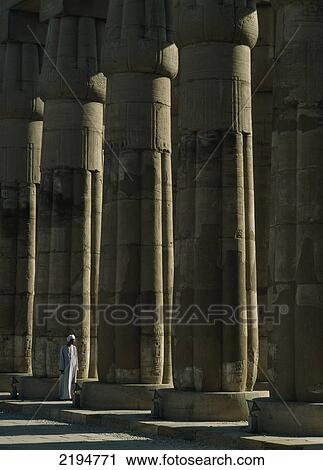 Egypt, Luxor Temple; Luxor, Temple guard beside papyrus-bundle columns in Court of Amenophis III View Large Photo Image Stock Image - Egypt, Luxor Temple; Luxor, Temple guard beside papyrus-bundle columns in Court of Amenophis III. Fotosearch