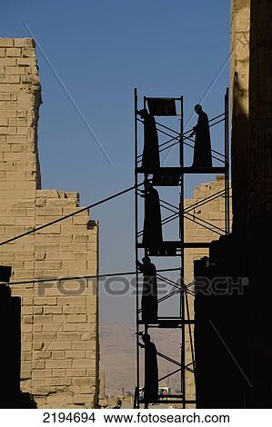 Egypt, Precinct of Amun; Luxor, Silhouette of men putting up scaffolding on Karnak Temple View Large Photo Image Picture - Egypt, Precinct of Amun; Luxor, Silhouette of men putting up scaffolding on Karnak Temple. Fotosearch